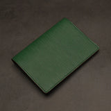 Green passport holder on a dark gray background