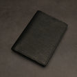 Black leather passport holder on a dark grey background