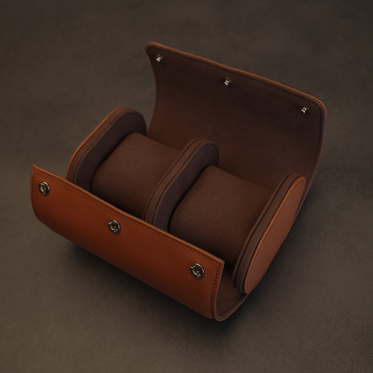 Inside view of an open, empty dual leather watch travel case with coffee brown microfiber interior and two pillows