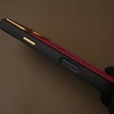 Luxury red textured leather phone case with gold accents and black bumper