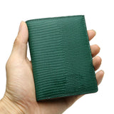 Hand holding a green lizard pattern slim wallet against a white background