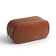 Brown leather toiletry bag with 2 zippers on a white background