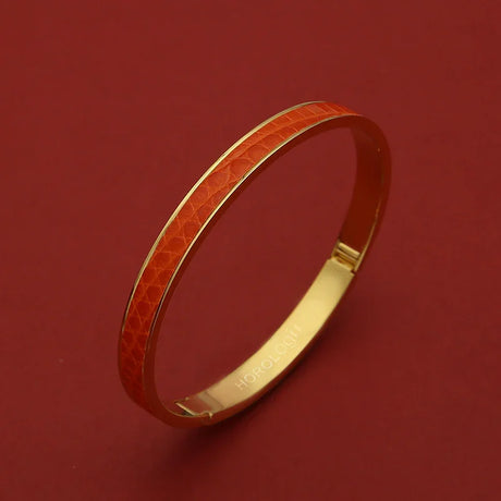 Luxury gold bangle with orange textured inlay, sleek design for elegant wristwear