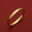 Gold bangle with textured pattern and engraved HOROLOGII, luxury accessory on red background