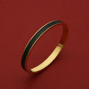 Gold bangle with black textured inlay, luxury leather-inspired design, elegant women's accessory