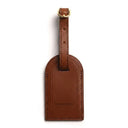 Brown leather luggage tag with gold accent on a white background