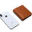 Smartphone with Apple logo next to a brown leather wallet on a white background