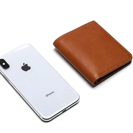 Smartphone with Apple logo next to a brown leather wallet on a white background