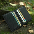 Black leather wallet with cards on a natural background