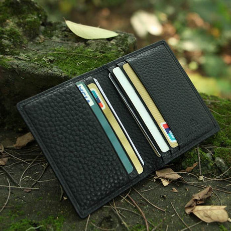 Black leather wallet with cards on a natural background